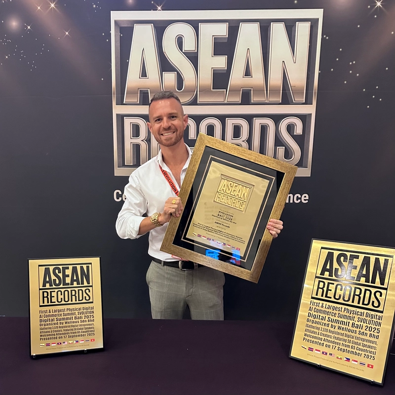 Chris Rowan at ASEAN Records holding a large gold-framed certificate of recognition